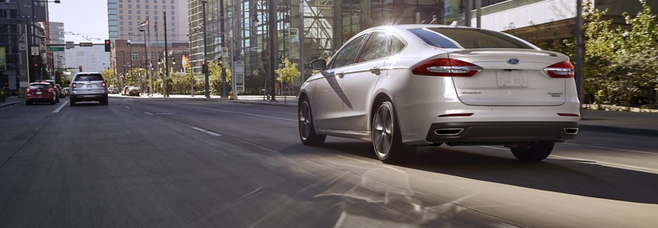 2020 ford fusion driving through the city on a sunny day